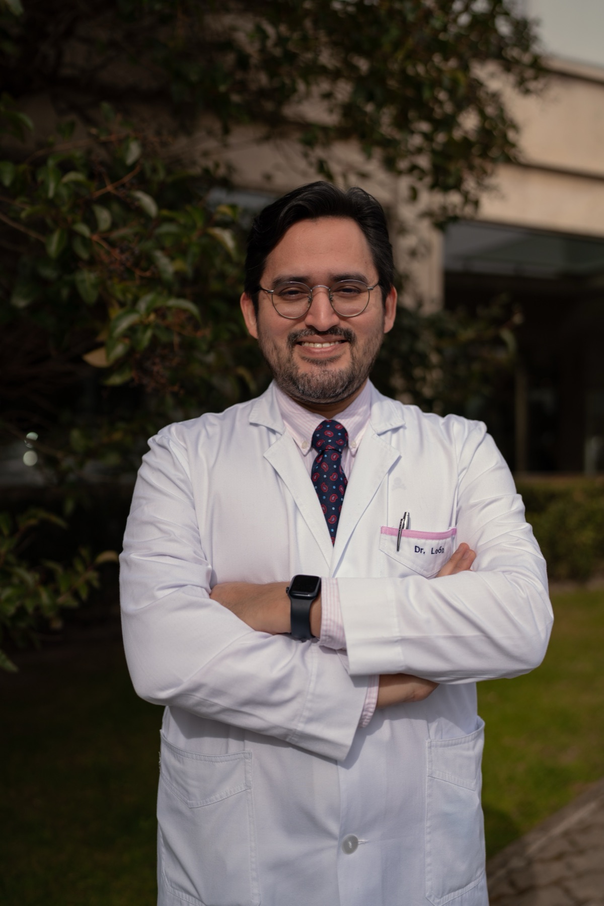 Dr. José Luis León Falconi, pediatra, con bata blanca y los brazos cruzados