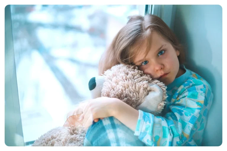 Niña con fiebre abrazada a un peluche