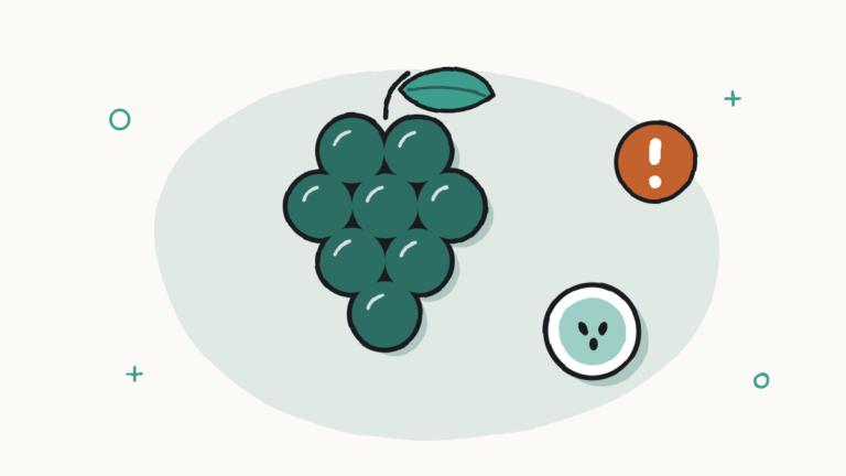 Racimo de uvas, una uva partida por la mitad y una señal de aviso